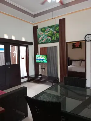 a living room with a glass table and a bedroom at Nyoman bali house villa in Seminyak