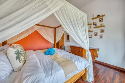 a bedroom with a canopy bed with a blue stuffed animal on it at Villa Ima in Canggu