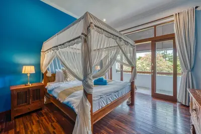 a bedroom with a canopy bed and a window at Villa Ima in Canggu
