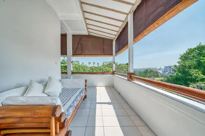 a balcony with a bed and a large window at Villa Ima in Canggu