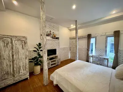 a bedroom with a white bed and a tv at Baliview homestay in Umalas