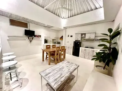 a living room with a table and a kitchen at Baliview homestay in Umalas