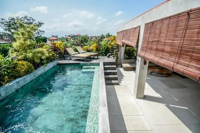 a swimming pool with a bench on top of a house at DUUR Apartments in Seminyak