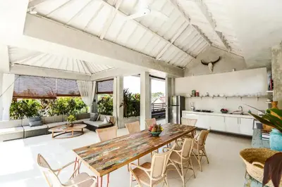 a kitchen and living room with a wooden table and chairs at DUUR Apartments in Seminyak