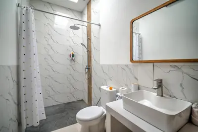 a bathroom with a sink and a toilet and a mirror at Villa Esha III in Seminyak