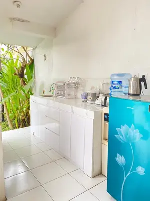 a kitchen with white cabinets and a blue refrigerator at Villa Music in Seminyak