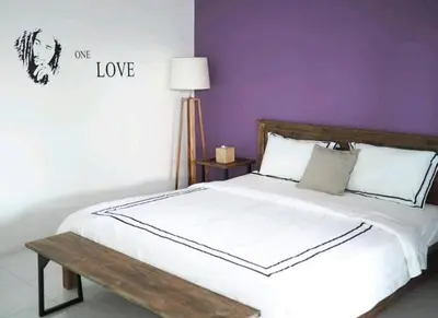 a bedroom with a white bed and purple walls at Villa Music in Seminyak