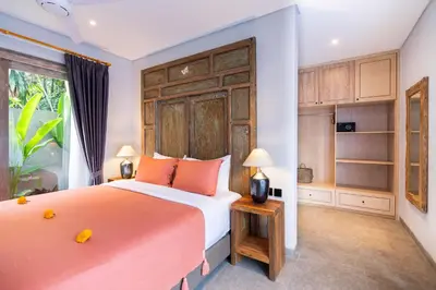 a bedroom with a large bed and a window at Villa Indah in Legian