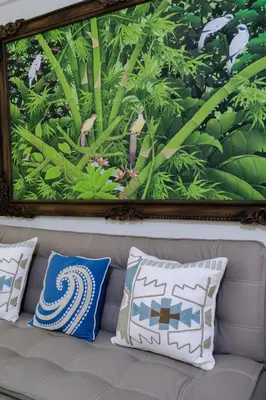 a painting on the wall above a couch with pillows at Private Apartment 6244 at Jayakarta Residence in Seminyak