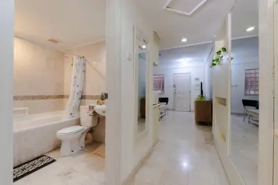 a bathroom with a toilet and a tub and a sink at Private Apartment 6244 at Jayakarta Residence in Seminyak