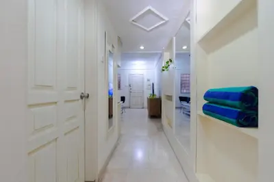 a hallway with a white door and blue towels at Private Apartment 6244 at Jayakarta Residence in Seminyak