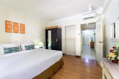 a bedroom with a large white bed and a hallway at Private Apartment 6244 at Jayakarta Residence in Seminyak