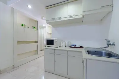 a white kitchen with a sink and a microwave at Private Apartment 6244 at Jayakarta Residence in Seminyak