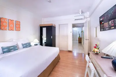 a bedroom with a large white bed and a desk at Private Apartment 6244 at Jayakarta Residence in Seminyak