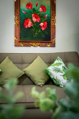 a couch with pillows and a painting on the wall at Private Apartment 6503 at the Jayakarta Residence in Seminyak