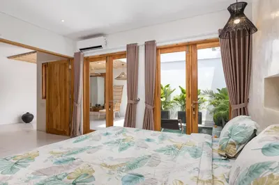 a bedroom with a bed and sliding glass doors at Spacious 1Br Villas in Seminyak in Seminyak