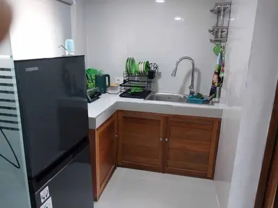 a kitchen with a sink and a black refrigerator at Thula Thula Bali Villas in Kerobokan