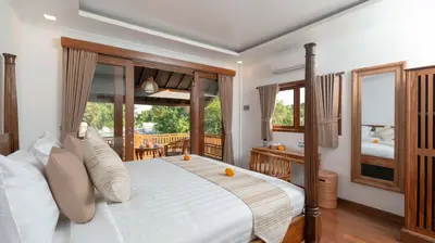a bedroom with a large bed and a balcony at Alarte Estate by Villa Finder in Seminyak
