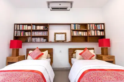 two beds in a room with book shelves at Alarte Estate by Villa Finder in Seminyak