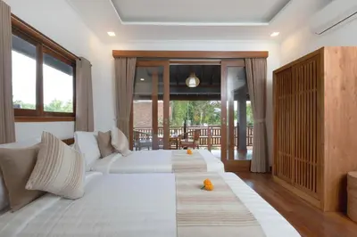 a bedroom with two beds and a large window at Alarte Estate by Villa Finder in Seminyak