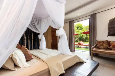 a bedroom with a bed with white drapes at Alarte Estate by Villa Finder in Seminyak