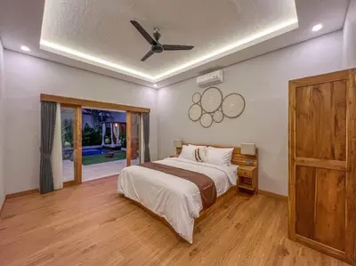 a bedroom with a bed and a ceiling fan at Villa Cakka Seminyak in Seminyak
