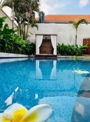 a swimming pool with a table in the middle at Villa Cakka Seminyak in Seminyak