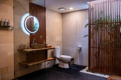 a bathroom with a toilet and a sink and a mirror at Villa Cakka Seminyak in Seminyak