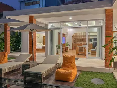 a patio with two chairs and an umbrella at Villa Cakka Seminyak in Seminyak