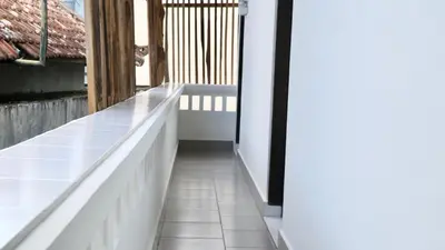 a balcony with a white tile floor and a window at Puri Beach Inn - Poppies 2 in Legian