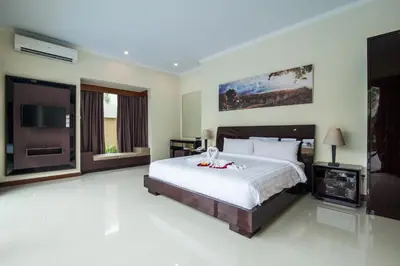 a bedroom with a large bed and a television at 1-BR Private Pool Villa Seminyak Kunti St in Seminyak