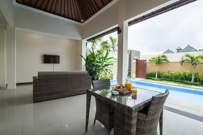 a living room with a table and chairs and a couch at 1-BR Private Pool Villa Seminyak Kunti St in Seminyak