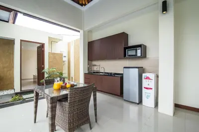 a kitchen with a table and a refrigerator at 1-BR Private Pool Villa Seminyak Kunti St in Seminyak