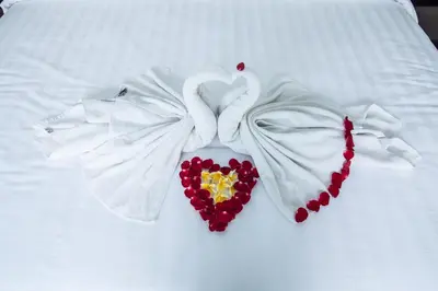 a pair of white towels with a heart on a bed at 1-BR Private Pool Villa Seminyak Kunti St in Seminyak