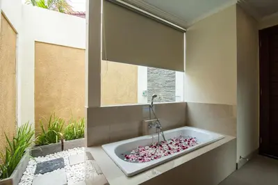 a bathroom with a bath tub filled with pink rocks at 1-BR Private Pool Villa Seminyak Kunti St in Seminyak