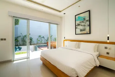 a bedroom with a large bed and a large window at Villa Gregana by Pertama Management in Seminyak