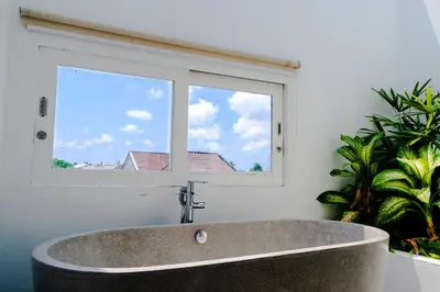 a bath tub in a bathroom with a window at Villa Gregana by Pertama Management in Seminyak