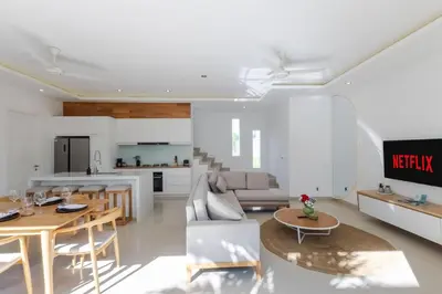 a living room with a table and a kitchen at Villa Gregana by Pertama Management in Seminyak