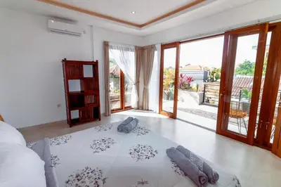 a bedroom with a bed in a room with sliding glass doors at Villa Shantia by Bby Diamond in Legian