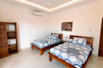 a bedroom with two beds and a cabinet at Villa Shantia by Bby Diamond in Legian