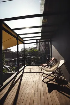 a deck with chairs sitting on top of a building at M Boutique Hostel in Seminyak
