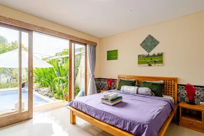 a bedroom with a bed and a swimming pool at Villa Naga, pool, Kitchen, terace and garden in Kerobokan