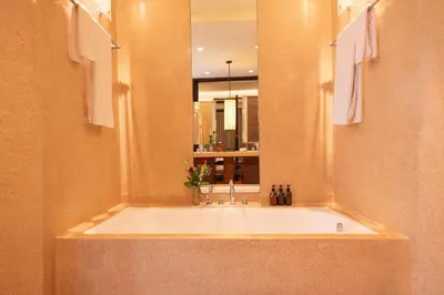 a bathroom with a large bath tub with a mirror at 1BR Suite Ocean View in Seminyak
