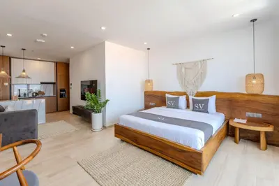 a bedroom with a large bed and a living room at Sunny Aparts 2 in Canggu