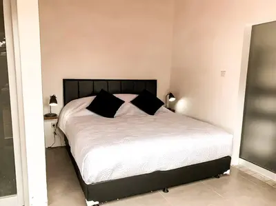 a bedroom with a large bed with black pillows at Elegant 5 Bdr villa in the heart of Seminyak in Seminyak