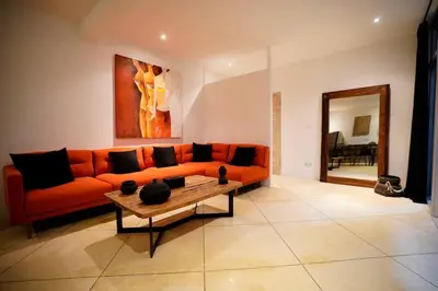 a living room with an orange couch and a table at Elegant 5 Bdr villa in the heart of Seminyak in Seminyak