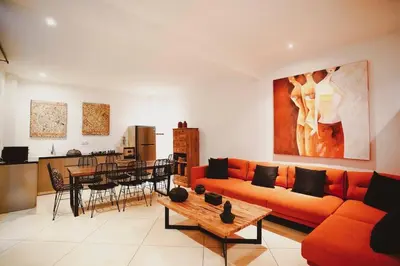 a living room with a orange couch and a table at Elegant 5 Bdr villa in the heart of Seminyak in Seminyak