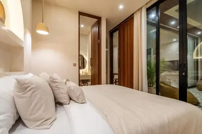 a bedroom with a large bed with white pillows at Casa Admire Villas in Legian