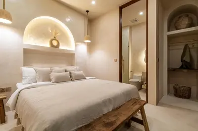 a bedroom with a large bed and a bathroom at Casa Admire Villas in Legian