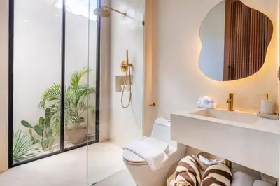 a bathroom with a sink and a toilet and a mirror at Casa Admire Villas in Legian